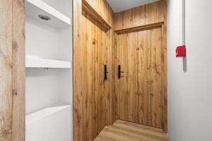 a wooden door in a bathroom with a bath tub at Central Platinum Apartments 10 in Rybnik