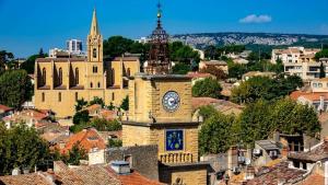a large building with a clock tower in a city at Casa Salon T2 Centre historique Wifi Climatisation in Salon-de-Provence
