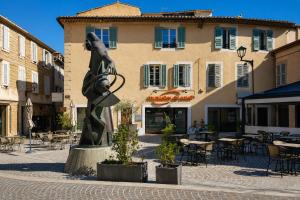 a statue in front of a building with tables and chairs at Casa Salon T2 Centre historique Wifi Climatisation in Salon-de-Provence