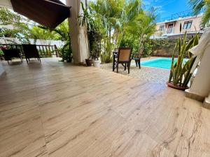 a patio with a wooden floor and a swimming pool at Villa Luck in Trou aux Biches