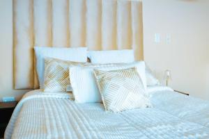 a bed with blue and white pillows on it at Best for last resorts in Kalkheuvel