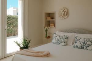 a white bedroom with a bed with a towel on it at La Peschiera in Monopoli +55 photos