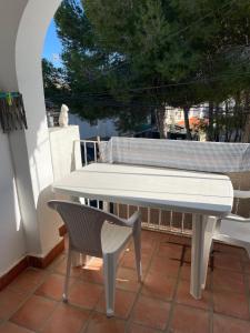 a white table and a chair on a patio at Appartement calme et confort in La Florida