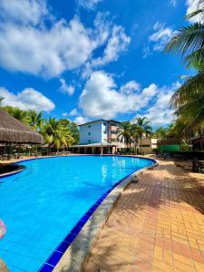 a swimming pool in a resort with palm trees at Pontal do Lago Flat Residence, aproveite dias incríveis em família às margens do lago Corumbá in Caldas Novas