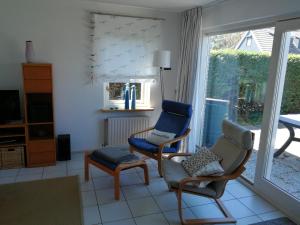 a living room with two chairs and a window at Grevelingen 24 Ouddorp in Ouddorp +5 photos