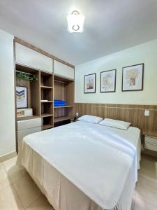 a bedroom with a large white bed in it at Pontal do Lago Flat Residence, aproveite dias incríveis em família às margens do lago Corumbá in Caldas Novas +279 photos