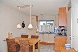 a kitchen with a wooden table and some chairs at Grevelingen 24 Ouddorp in Ouddorp