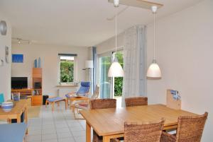 a dining room and living room with a table and chairs at Grevelingen 24 Ouddorp in Ouddorp
