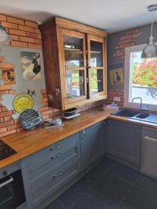a kitchen with a wooden counter top and a sink at le Tic Tac in Vergongheon