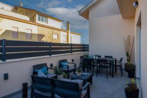 a patio with chairs and tables on a balcony at Alba Stays in Ladispoli