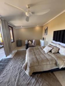 a bedroom with a large bed with a ceiling fan at Best for last resorts in Kalkheuvel
