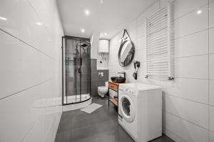 a white bathroom with a washing machine and a sink at Central Platinum Apartments 11 in Rybnik