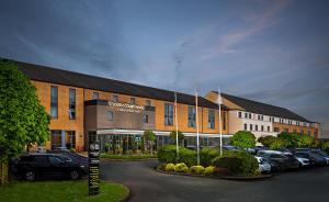 a large building with cars parked in a parking lot at Great National South Court Hotel in Limerick