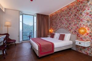 a bedroom with a bed with a floral wall at Grand Hotel Menaggio in Menaggio +162 photos