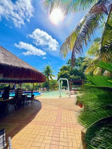 a resort with a swimming pool and palm trees at Pontal do Lago Flat Residence, aproveite dias incríveis em família às margens do lago Corumbá in Caldas Novas
