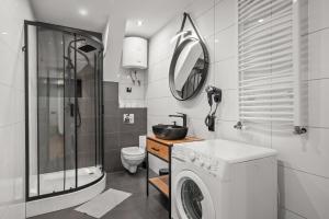 a bathroom with a washing machine and a sink at Central Platinum Apartments 11 in Rybnik +20 photos