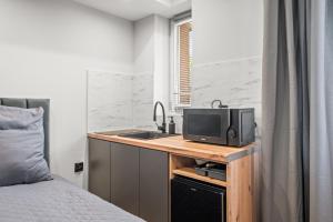 a bedroom with a bed and a desk with a television at Central Platinum Apartments 11 in Rybnik