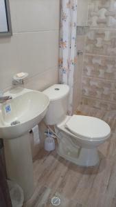 a bathroom with a white toilet and a sink at Cabaña MAR PLAYA in San Antero