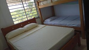 a bedroom with two bunk beds and a window at Cabaña MAR PLAYA in San Antero