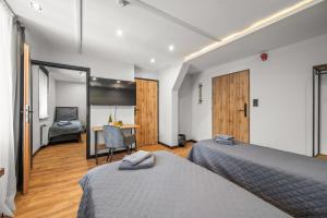a bedroom with two beds and a desk in a room at Central Platinum Apartments 11 in Rybnik