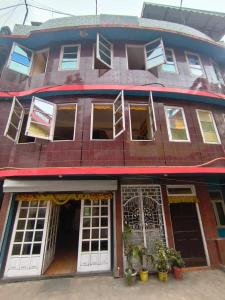 a red brick building with white doors and windows at Hotel Kalika Darjeeling in Darjeeling