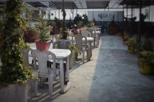 a row of tables and chairs with potted plants at Hotel Kalika Darjeeling in Darjeeling