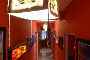 a hallway with orange walls and pictures on the walls at Hotel Kalika Darjeeling in Darjeeling +5 photos