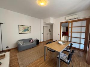 a living room with a table and a couch at Montegrappa smart stay Modena in Modena
