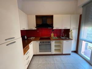 a kitchen with white cabinets and a stove top oven at Montegrappa smart stay Modena in Modena +3 photos