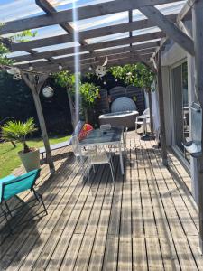 a patio with a table and chairs under a wooden pergola at le Tic Tac in Vergongheon