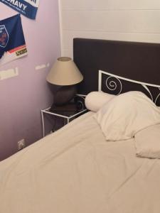 a bedroom with a bed and a lamp on a table at le Tic Tac in Vergongheon