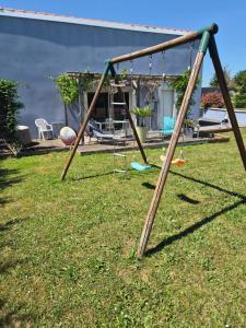 a swing set in a yard next to a house at le Tic Tac in Vergongheon