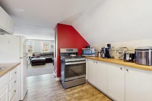 a kitchen with white cabinets and a red wall at East End Annex in Portland