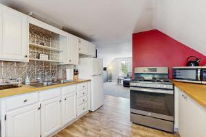a kitchen with white cabinets and a red wall at East End Annex in Portland +7 photos