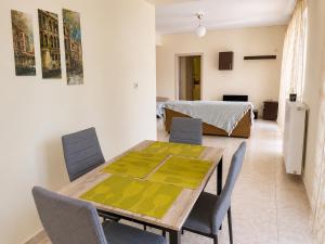 a dining room with a table and chairs and a bedroom at Treasure B&B - Garden Stay in Paloukia Salamina in Paloúkia +16 photos