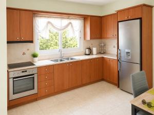 a kitchen with wooden cabinets and a sink and a window at Treasure B&B - Garden Stay in Paloukia Salamina in Paloúkia