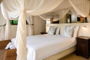 a bedroom with a white bed with a canopy at Amazing mountain views! Solar powered! in Hoedspruit +48 photos