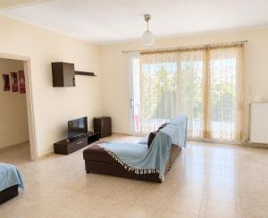 a large living room with a bed and a television at Treasure B&B - Garden Stay in Paloukia Salamina in Paloúkia