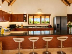 a kitchen with a counter with bar stools at Amazing mountain views! Solar powered! in Hoedspruit