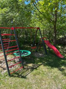 a playground with a slide and a swing at domki pestka in Jastrzębia Góra