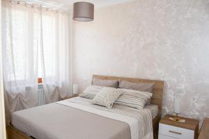 a bedroom with a bed with a white wall at 10 min from the lake, Spacious & Modern - Lalaland in Porto Ceresio
