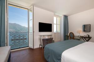 a hotel room with a bed and a large window at Grand Hotel Menaggio in Menaggio