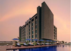 a hotel with blue umbrellas and a pool at Radisson Blu Hotel New Delhi Paschim Vihar in New Delhi