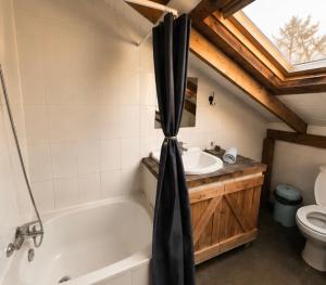 a bathroom with a tub and a sink and a toilet at Hostal Climb House in Puerto Varas +72 photos
