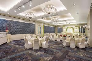 a banquet hall with white tables and chairs and chandeliers at Radisson Blu Hotel New Delhi Paschim Vihar in New Delhi +64 photos