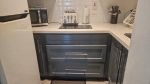 a kitchen with a counter top with a microwave and a stove at Apartment Treasure at Sandcastles in Ocho Rios