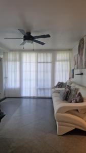 a living room with a ceiling fan and a couch at Apartment Treasure at Sandcastles in Ocho Rios +22 photos