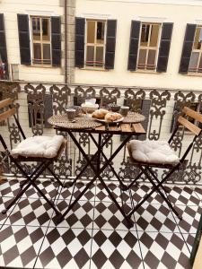 a table with two chairs and a table with food on it at CASA JACK Open Space Piazza Galimberti in Cuneo