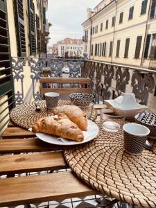 a table with two plates of food on a balcony at CASA JACK Open Space Piazza Galimberti in Cuneo