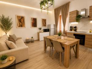 a kitchen and living room with a table and a couch at Sicily Luxury Apartments in Palermo